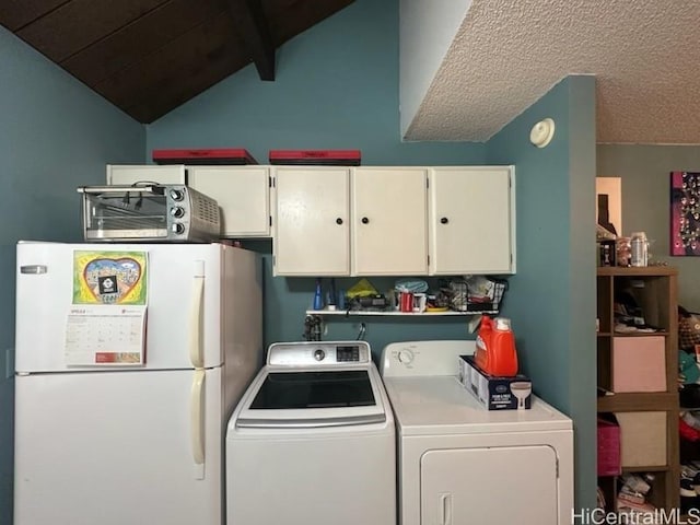 clothes washing area with a toaster, cabinet space, and washing machine and dryer
