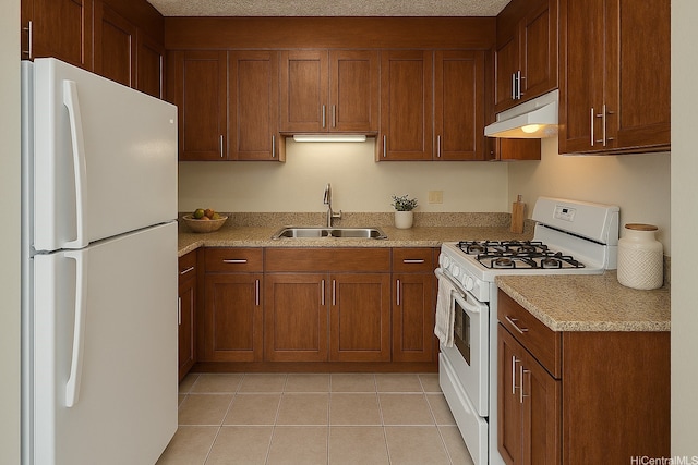 kitchen featuring brown cabinetry, a sink, under cabinet range hood, and white appliances