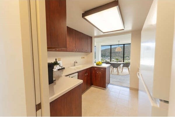 250 Kawaihae St Unit 15B, Honolulu, HI 96825 - kitchen featuring light floors, light countertops, a wall of windows, a sink, and a peninsula