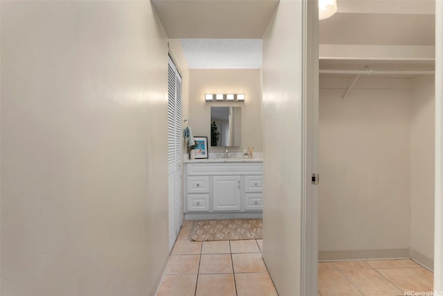 98-1038 Moanalua Rd Unit 1502, Aiea, HI 96701 - bathroom with tile patterned floors, vanity, a spacious closet, and baseboards
