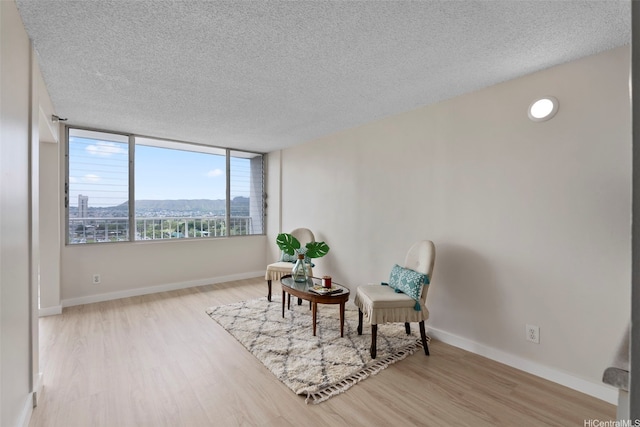 2542 Date St Unit 904, Honolulu, HI 96826 - sitting room with baseboards, a textured ceiling, and wood finished floors