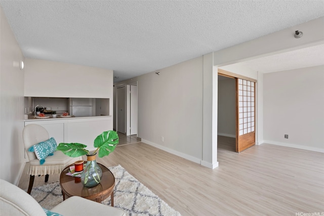 2542 Date St Unit 904, Honolulu, HI 96826 - sitting room with a textured ceiling, baseboards, and wood finished floors