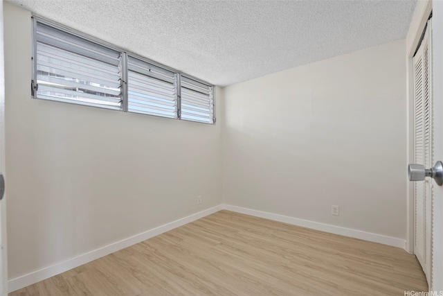 2542 Date St Unit 904, Honolulu, HI 96826 - unfurnished room featuring light wood-type flooring, a textured ceiling, baseboards, and a wealth of natural light