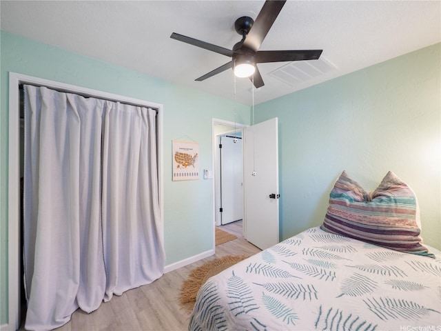 bedroom featuring baseboards, visible vents, ceiling fan, and light wood-style flooring