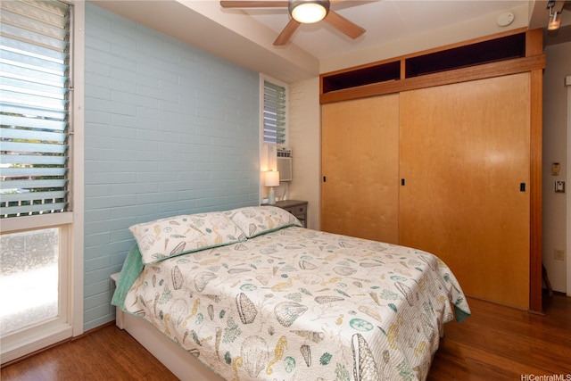 bedroom featuring a ceiling fan, wood finished floors, and a closet