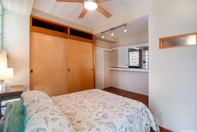 bedroom with track lighting and wood finished floors