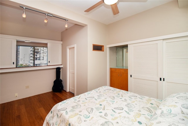 bedroom with track lighting, a ceiling fan, a closet, and wood finished floors