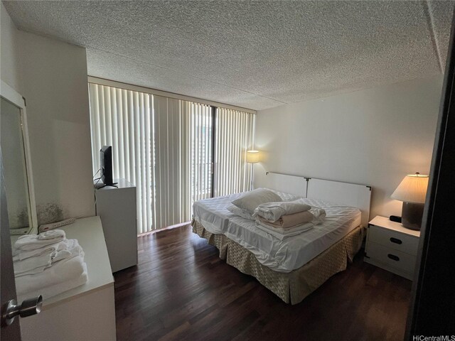 bedroom featuring a textured ceiling and dark wood-style flooring