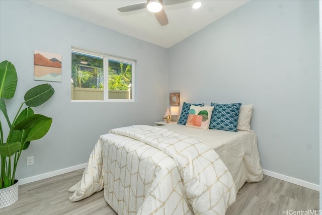 bedroom featuring baseboards, wood finished floors, a ceiling fan, and vaulted ceiling