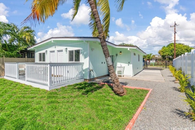view of home's exterior featuring driveway, a yard, and fence