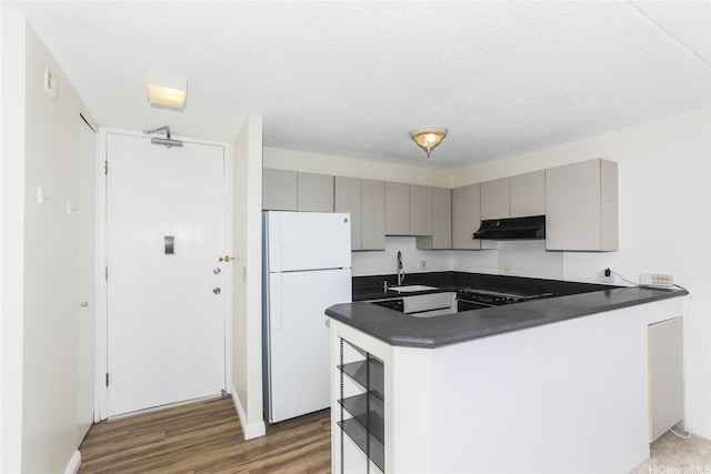 411 Hobron Ln Unit 1710, Honolulu, HI 96813 - kitchen with freestanding refrigerator, under cabinet range hood, gray cabinets, dark countertops, and a textured ceiling