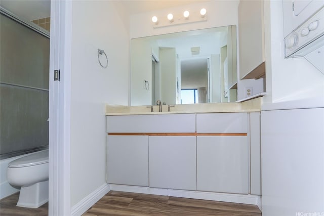 411 Hobron Ln Unit 1710, Honolulu, HI 96813 - full bathroom featuring vanity, wood finished floors, and a shower with shower door