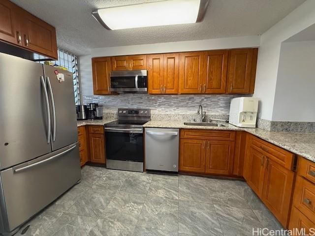 500 University Ave Unit 917, Honolulu, HI 96826 - kitchen featuring brown cabinetry, a sink, tasteful backsplash, and stainless steel appliances