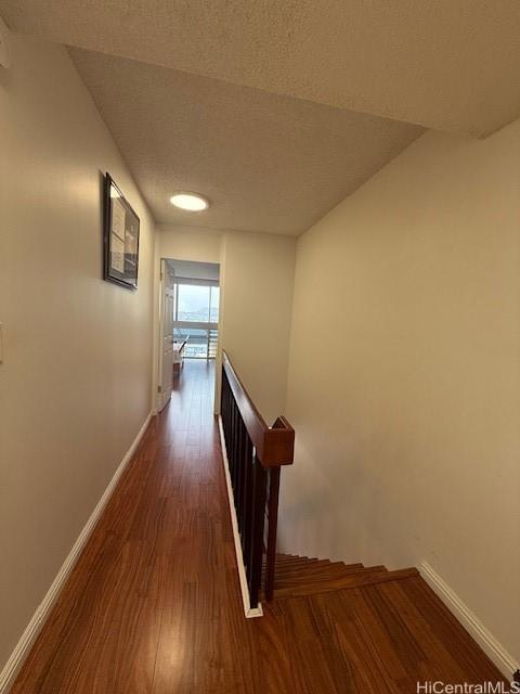 500 University Ave Unit 917, Honolulu, HI 96826 - hallway featuring baseboards, wood finished floors, and an upstairs landing