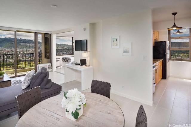 dining space with baseboards, a mountain view, and light tile patterned floors