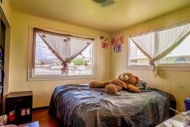 94-941 Awanei St, Waipahu, HI 96797 - bedroom with visible vents, wood finished floors, wooden walls, and multiple windows