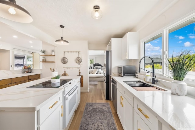 552 Kalolina St, Kailua, HI 96734 - kitchen featuring a center island, a sink, light wood finished floors, stainless steel appliances, and white cabinetry