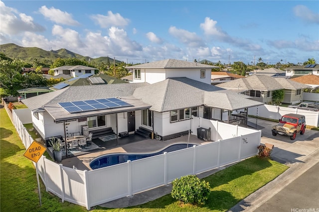 552 Kalolina St, Kailua, HI 96734 - rear view of property with a fenced backyard, roof with shingles, entry steps, a residential view, and solar panels