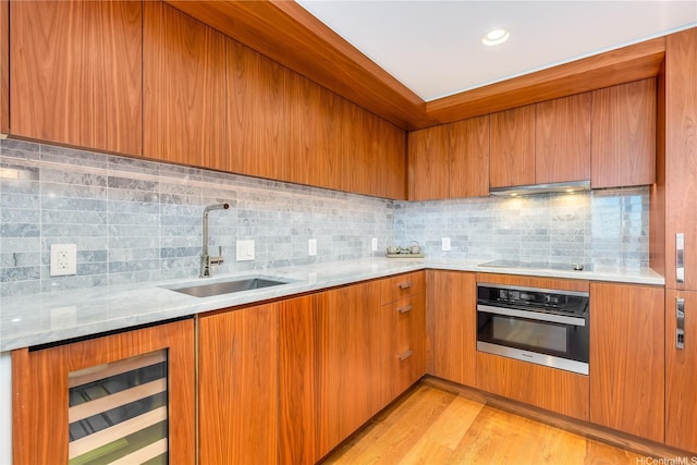 2139 Kuhio Ave Fl 34Th, Honolulu, HI 96815 - kitchen with stainless steel oven, black electric stovetop, under cabinet range hood, tasteful backsplash, and a sink