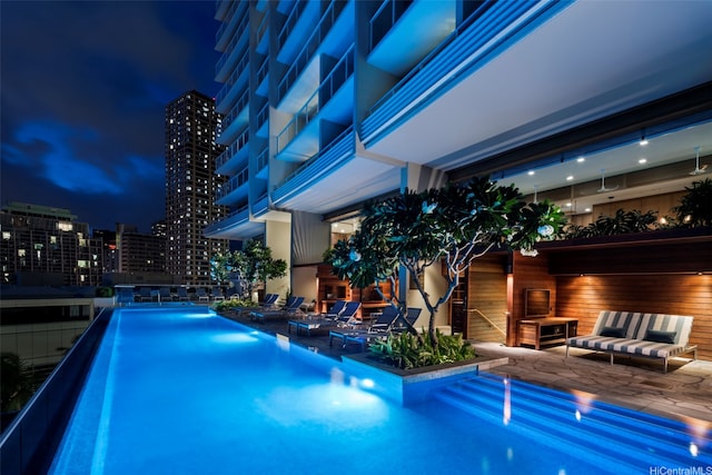 2139 Kuhio Ave Fl 34Th, Honolulu, HI 96815 - pool at night featuring a community pool, a patio, and a view of city lights