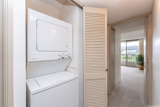 500 Lunalilo Home Rd Unit 25B, Honolulu, HI 96825 - washroom featuring laundry area, stacked washer and dryer, a textured ceiling, and light colored carpet
