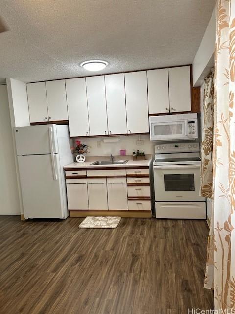 kitchen featuring a sink, dark wood-style flooring, white cabinets, and white appliances