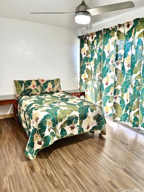 bedroom with baseboards, a ceiling fan, and wood finished floors