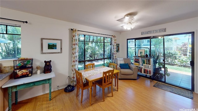 dining area featuring light wood-style floors, a ceiling fan, and baseboards