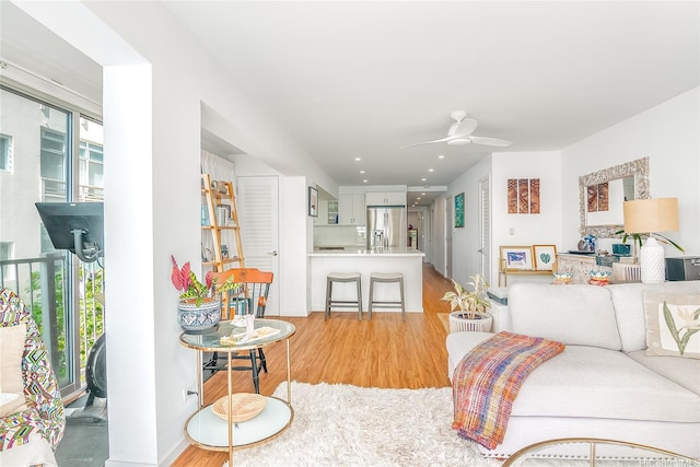 living room featuring light wood-style flooring and a ceiling fan