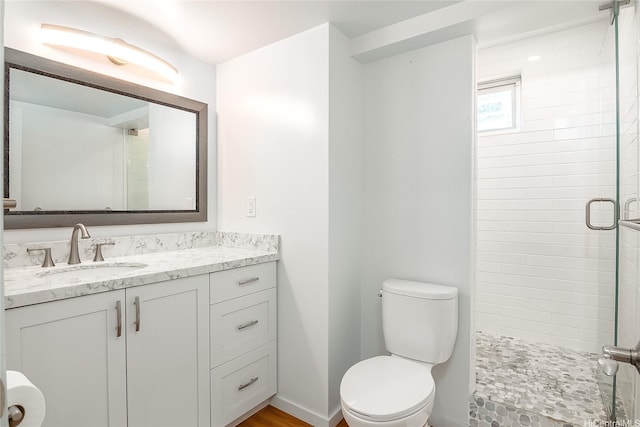 full bath with a shower stall, baseboards, vanity, and toilet