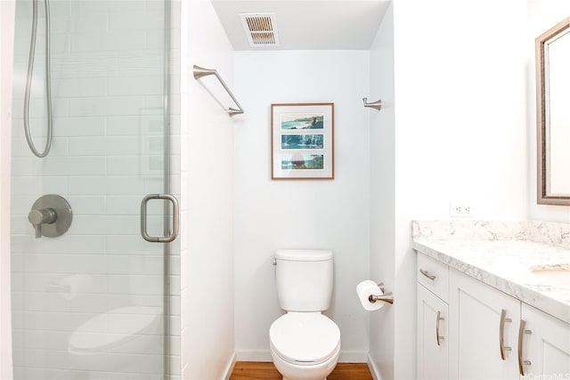 full bathroom with toilet, baseboards, visible vents, a shower stall, and vanity