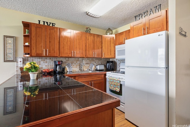 2452 Tusitala St Unit 908, Honolulu, HI 96815 - kitchen with a textured ceiling, open shelves, brown cabinets, a sink, and white appliances