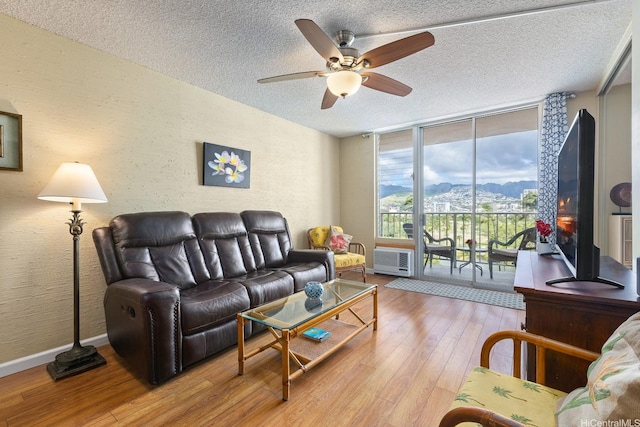 2452 Tusitala St Unit 908, Honolulu, HI 96815 - living area with ceiling fan, a wall of windows, a textured ceiling, baseboards, and wood finished floors