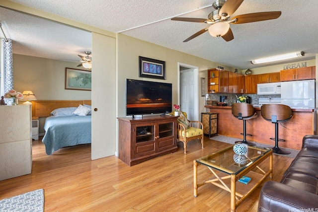 2452 Tusitala St Unit 908, Honolulu, HI 96815 - living room with light wood-style flooring, a ceiling fan, and a textured ceiling