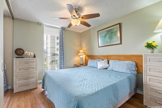 2452 Tusitala St Unit 908, Honolulu, HI 96815 - bedroom featuring a textured ceiling, a ceiling fan, and wood finished floors