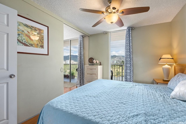 2452 Tusitala St Unit 908, Honolulu, HI 96815 - bedroom featuring access to outside, a textured ceiling, a mountain view, and multiple windows