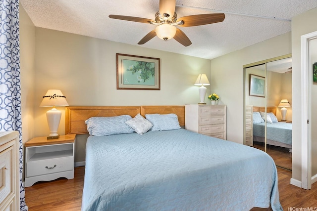 2452 Tusitala St Unit 908, Honolulu, HI 96815 - bedroom featuring a textured ceiling, a ceiling fan, a closet, and wood finished floors