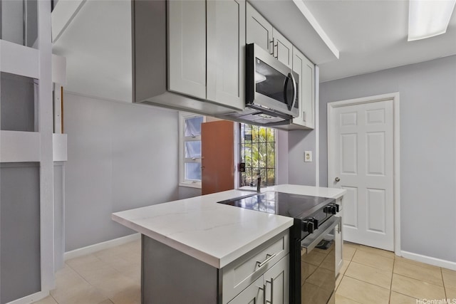 95-100 Moenamanu St Unit 458, Mililani, HI 96789 - kitchen with stainless steel appliances, baseboards, light tile patterned floors, an island with sink, and gray cabinetry