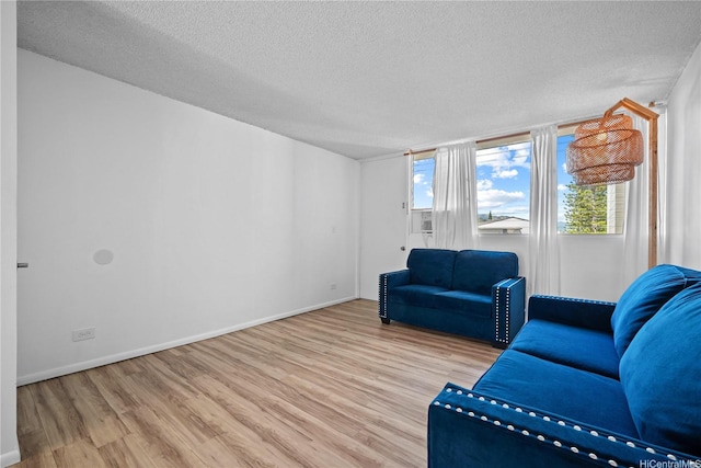 46-270 Kahuhipa St Unit A419, Kaneohe, HI 96744 - sitting room featuring wood finished floors, a textured ceiling, and baseboards