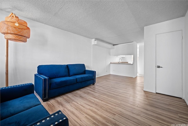 46-270 Kahuhipa St Unit A419, Kaneohe, HI 96744 - unfurnished living room with wood finished floors, a sink, and a textured ceiling