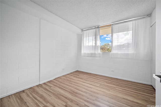 46-270 Kahuhipa St Unit A419, Kaneohe, HI 96744 - empty room with a textured ceiling, concrete block wall, and light wood-style floors