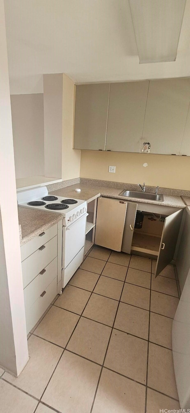 kitchen with light tile patterned floors, white range with electric cooktop, light countertops, and a sink