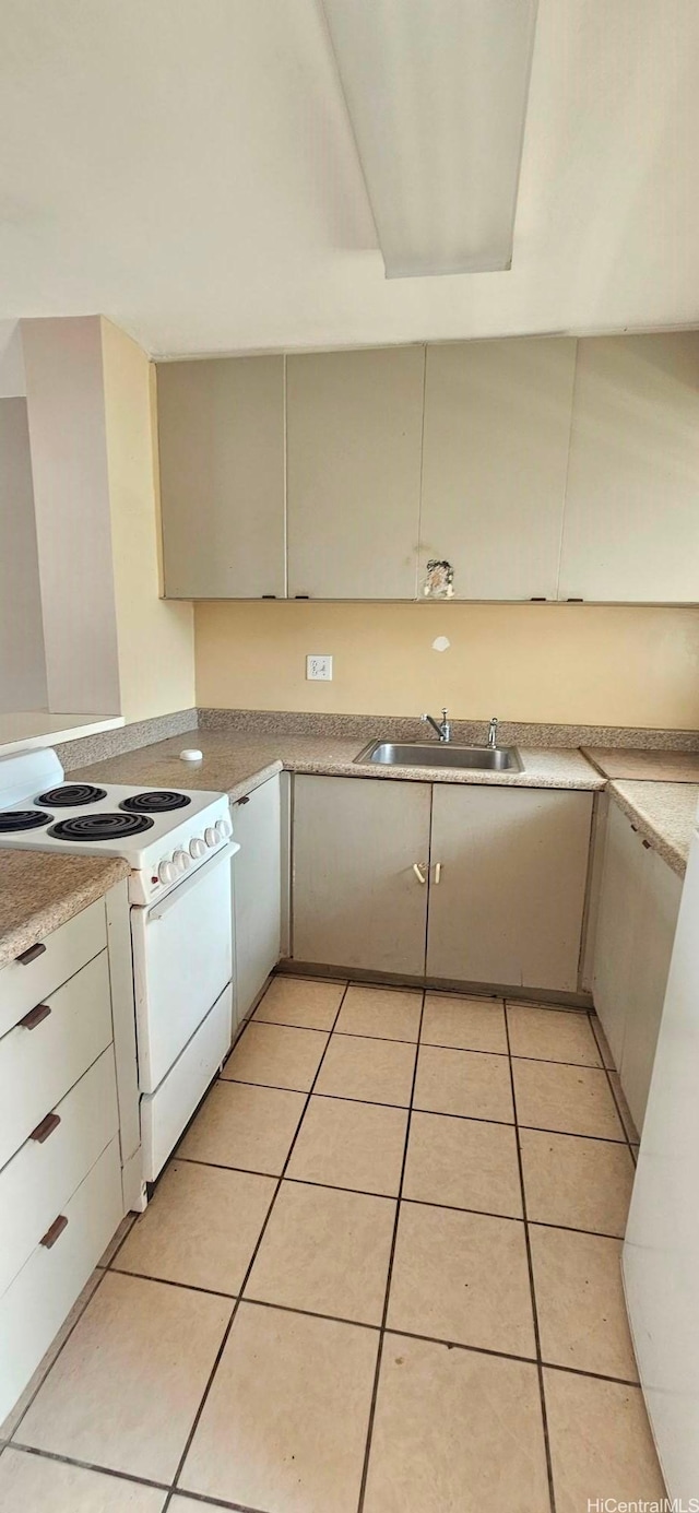kitchen with light tile patterned floors, white electric range oven, light countertops, and a sink