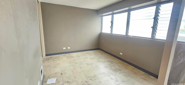 unfurnished room with baseboards, visible vents, and tile patterned floors