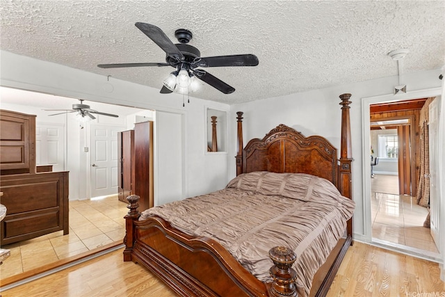 bedroom featuring a textured ceiling, ceiling fan, and light wood finished floors