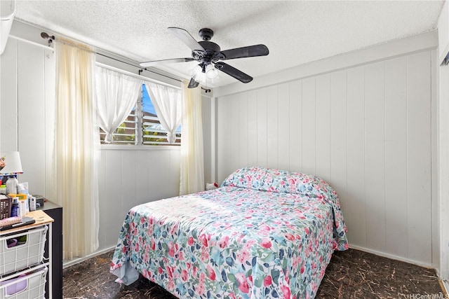 bedroom with marble finish floor, a ceiling fan, and a textured ceiling