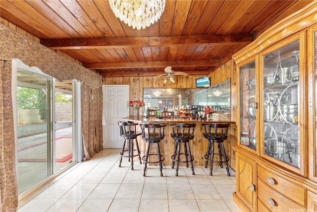 bar with beam ceiling, light tile patterned floors, and wood ceiling