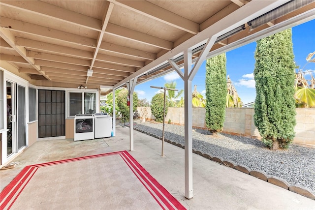 view of patio featuring independent washer and dryer and a fenced backyard