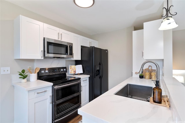 91-1860 Luahoana St Unit 114, Ewa Beach, HI 96706 - kitchen featuring appliances with stainless steel finishes, a sink, white cabinetry, decorative light fixtures, and light stone counters