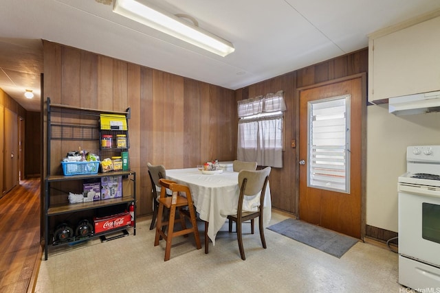 dining room with wood walls and light floors